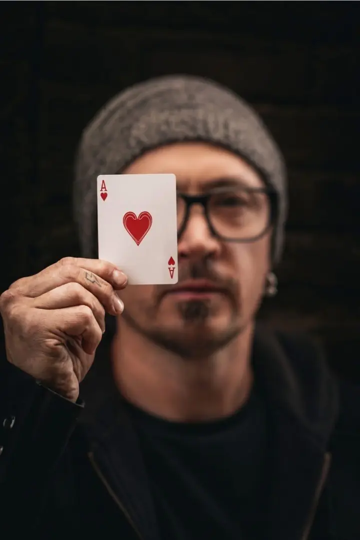 Tripp Coleman holding up the ace of hearts in front of his face