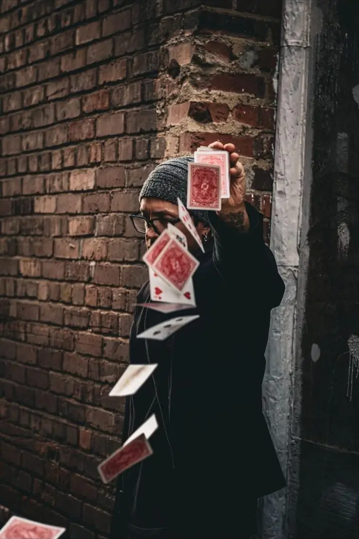 Tripp flinging cards against a brick wall